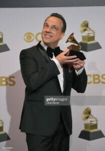 Carlos holding grammy award