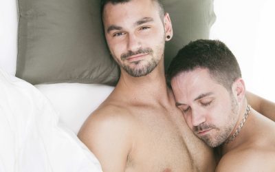 A homosexual couple onder a bed in studio white on studio.