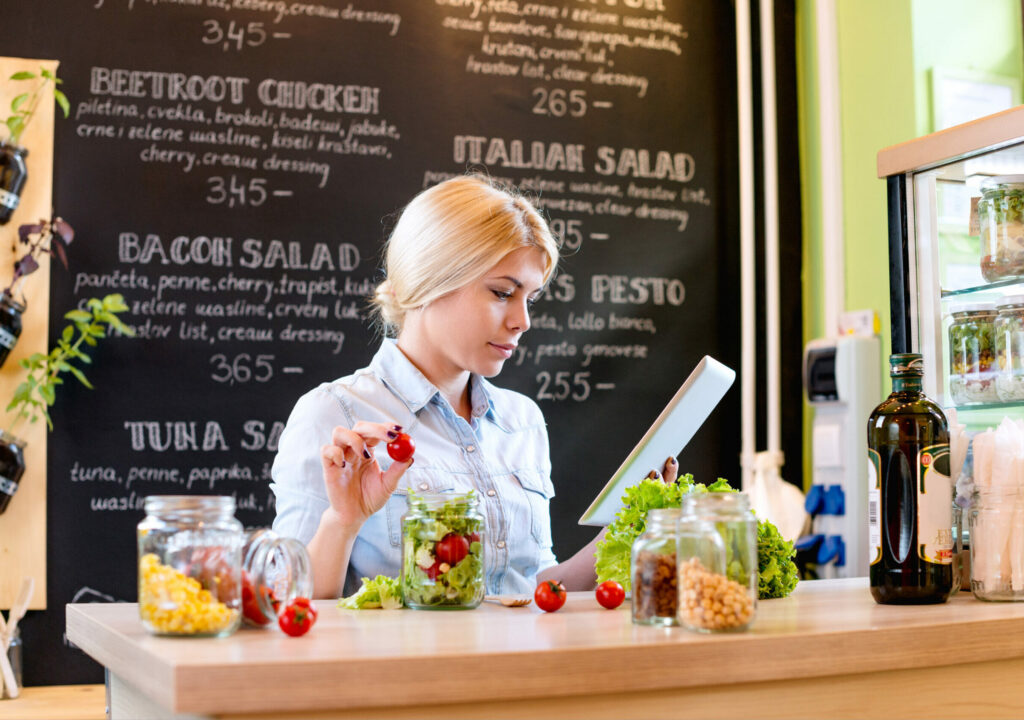 Small business owner reading the recipe on a digital tablet