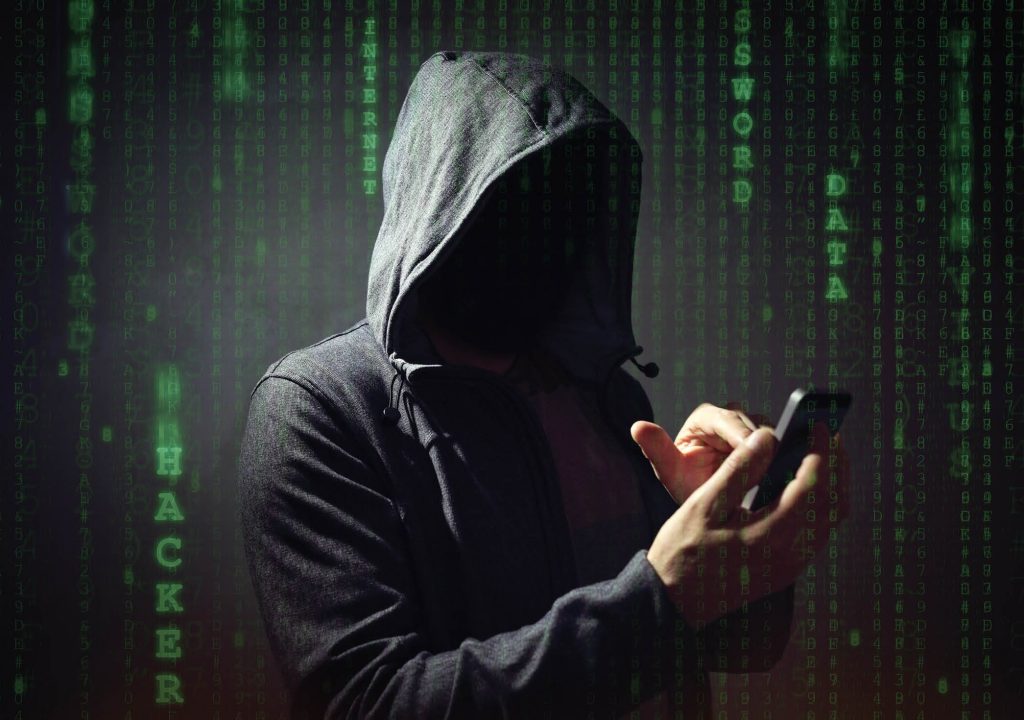 Computer hacker with mobile phone smartphone stealing data