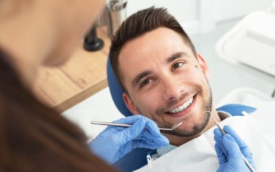 Man having a visit at the dentist`s. Handsome patient sitting on chair at dentist office in dental clinic