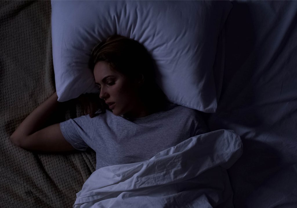 Beautiful female snoring in bed, serious health problems, sleep apnea risk, stock photo