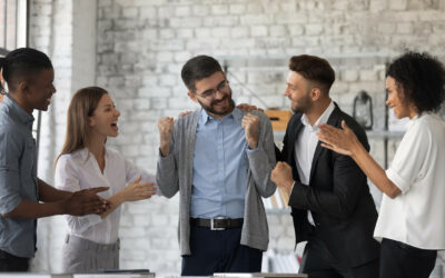 Smiling multiracial businesspeople congratulate colleague with job success or achievement. Happy supportive diverse multiethnic employees greet excited male worker with work promotion.