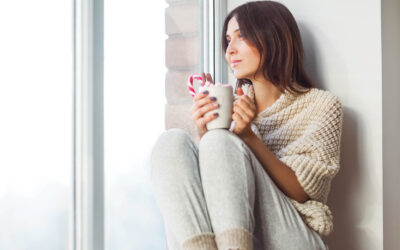 Woman siting by the window drinking coffee
