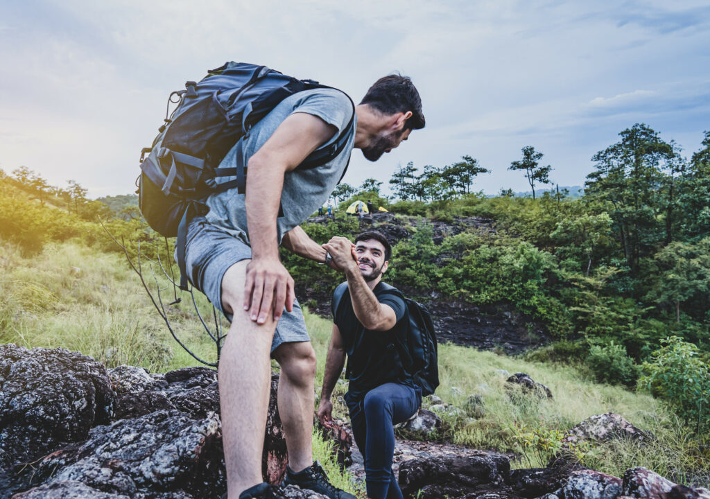 People trekking and helping each other,hikers climbing up on the mountain, Teamwork and hiking concepts ,we travel together