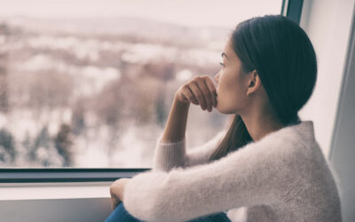 Sad pensive woman at home Winter depression - seasonal affective disorder mental health looking out the window alone. Self isolation