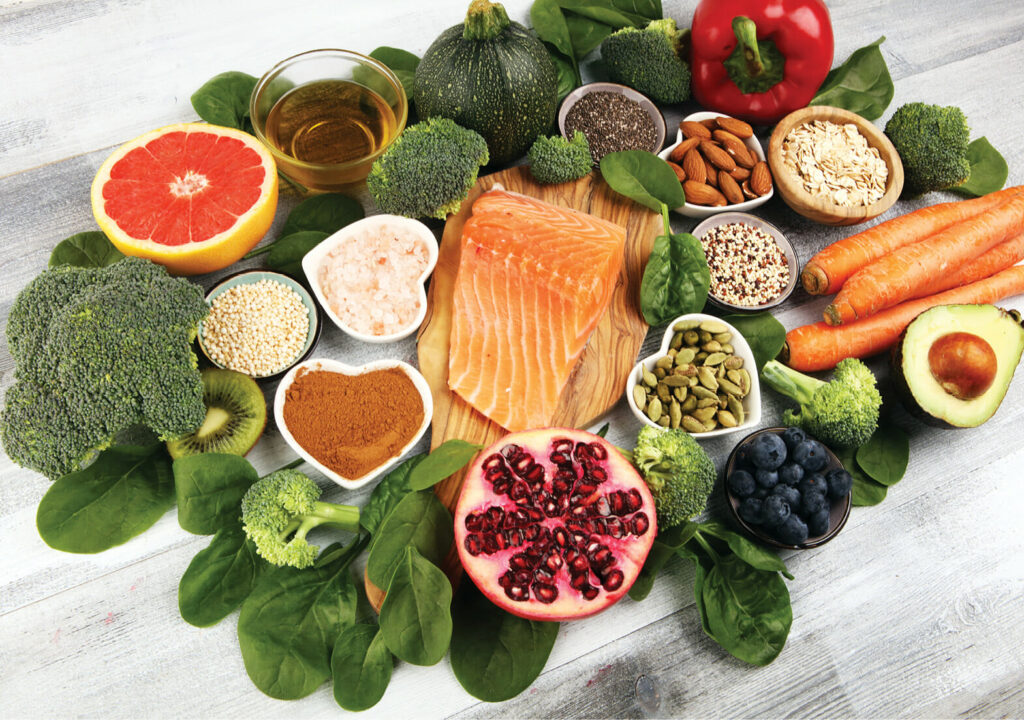 Healthy food clean eating selection: fish, fruit, vegetable, cereal, leaf vegetable on background