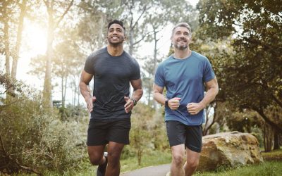 Running team, fitness and men in forest with cardio, athlete with personal trainer for support in sports and health. Exercise friends, diversity and runner club, healthy and training for race outdoor.