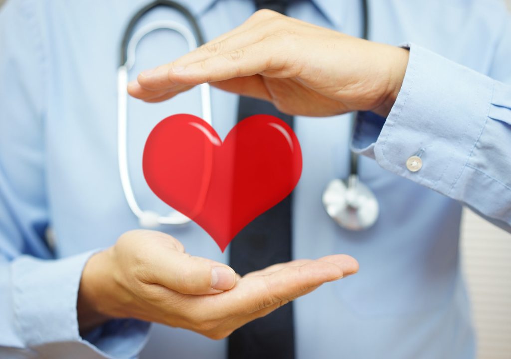 Doctor is protecting heart with hands. Health care and Cardiovascular diseases concept