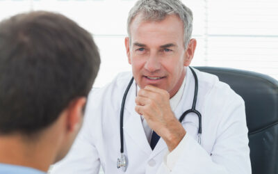 Attentive doctor listening to his patient in bright surgery