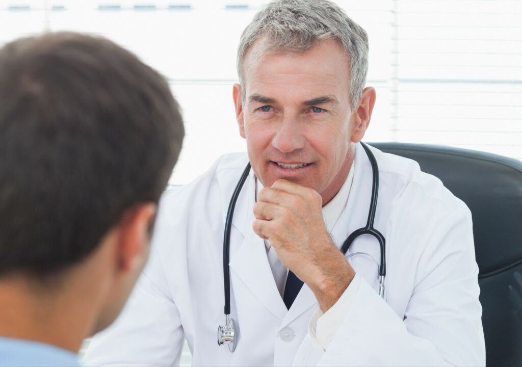 Attentive doctor listening to his patient in bright surgery