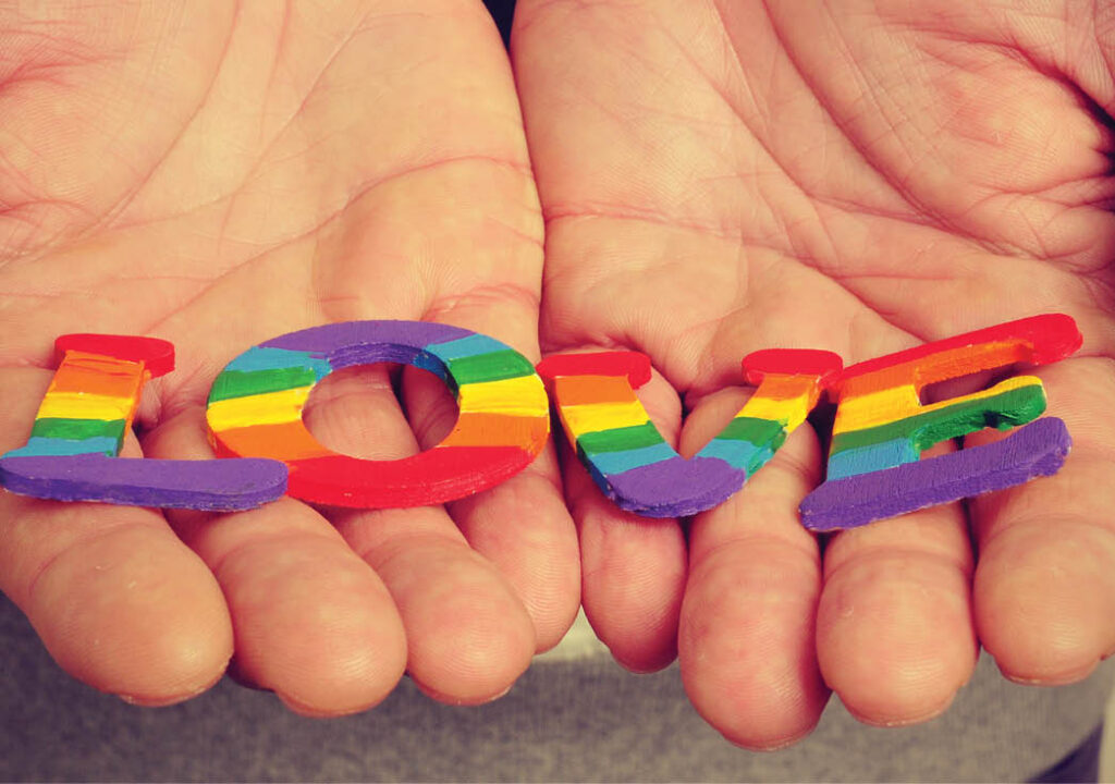 Hands holding Rainbow colored LOVE letters