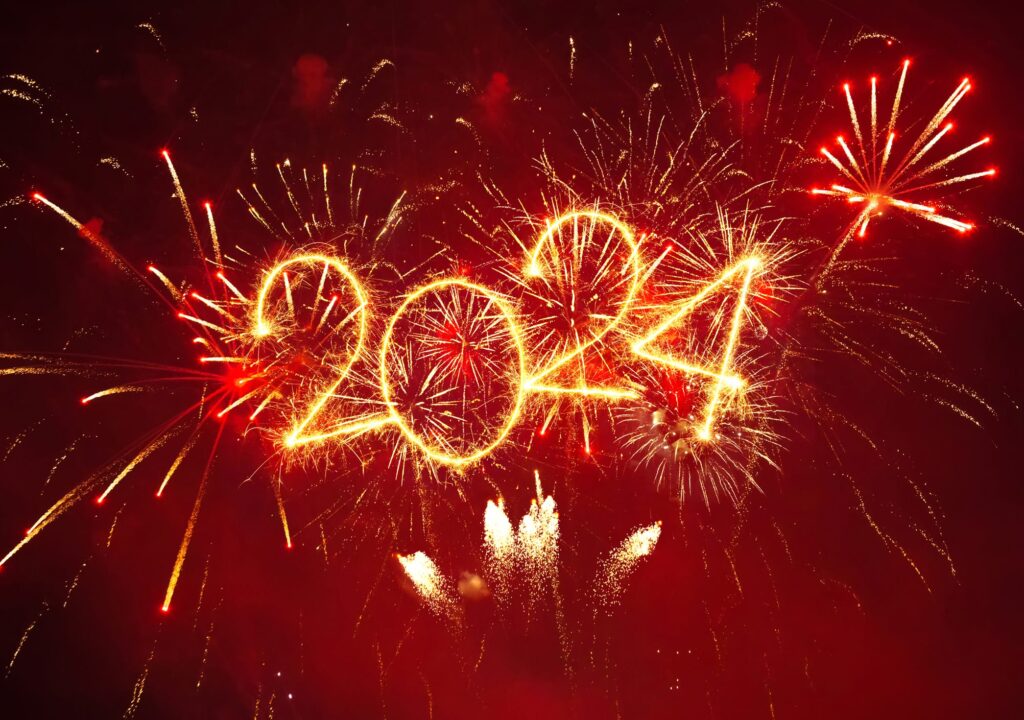 Happy New Year 2024. Beautiful New year Wallpaper, Poster. Creative holiday web banner or Greeting card with red fireworks and sparkling text 2024 on night sky background