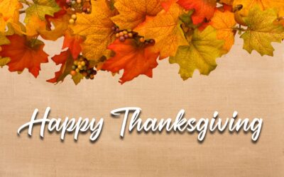 Fall leaves making a border on a beige background, fall border and a text of Happy Thanksgiving