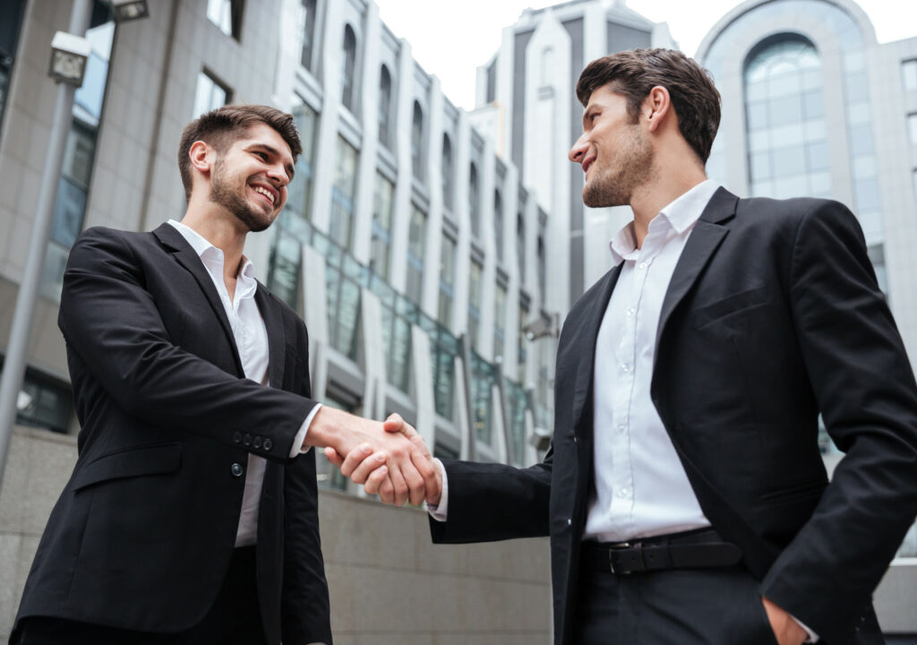 two-happy-businessmen-standing-and-shaking-hands