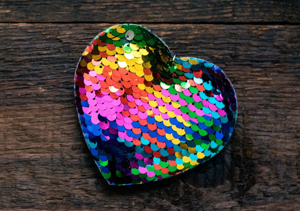 Valentines Day background, mockup with one Lgbt rainbow heart on rustic wooden background. Valentine Day, love, romance, dating concept, copy space