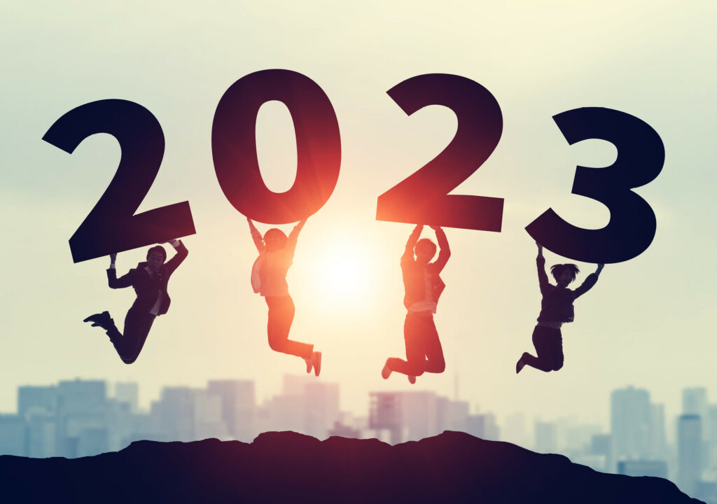 Group of people jumping together. 2023 New Year concept. Wide angle visual for banners or advertisements.