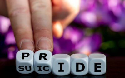 Symbol for LGBTQ mental health and suicide prevention. Hand turns dice and changes the word 