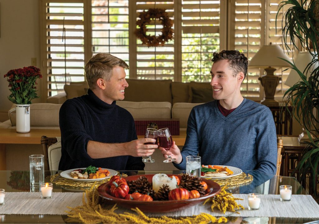Two Men Raising Their Glasses During an Autumn Dinner
