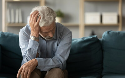 Frustrated unhappy middle aged mature man sitting on sofa, feeling depressed alone at home. Confused senior retired grandfather worrying about difficult life decision, copy space, old people solitude.