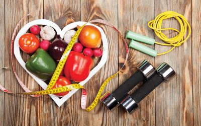 Sport and diet. Vegetables, dumbbells and centimeter. Peppers, tomatoes, garlic, onions, and radishes in the heart on rustic background