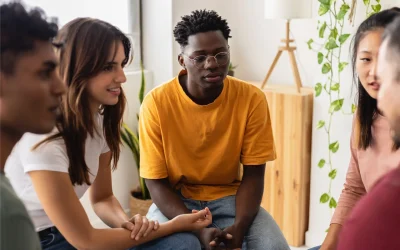 Multiracial people sitting in circle during group therapy supporting each other. Diversity, mental health and support concept. People communicating while sitting in circle and gesturing.